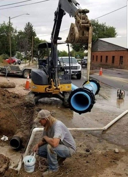 Crew member working next to a large pipe