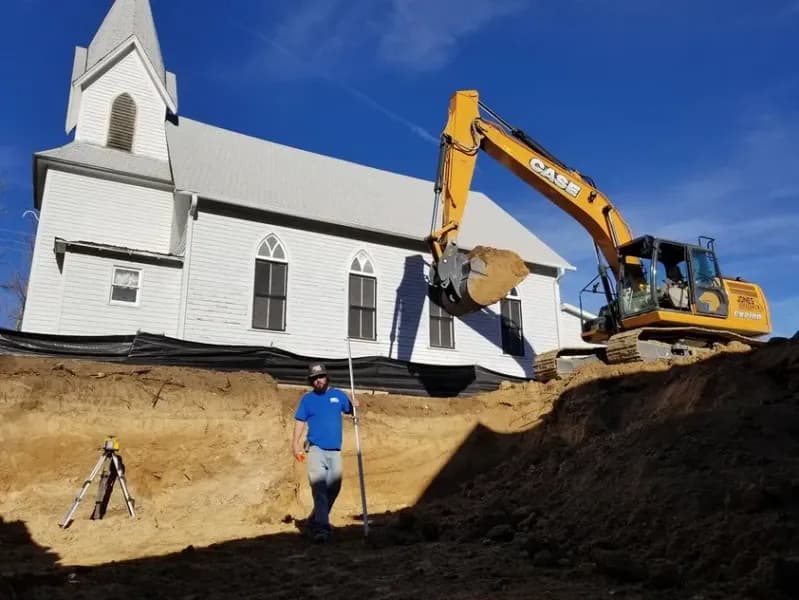 Team member in front of a CASE excavator
